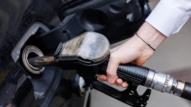 Eine Person tankt ein Auto mit einer Dieselpistole an einer Zapfsäule.