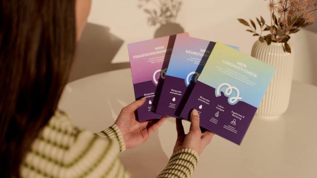 Eine Frau hält Testkits von Bipa und MavieMe in der Hand. 