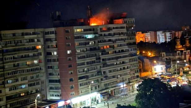 Fire burns on the roof of a 10-story block of flats after a drone crashed into the building in Galati