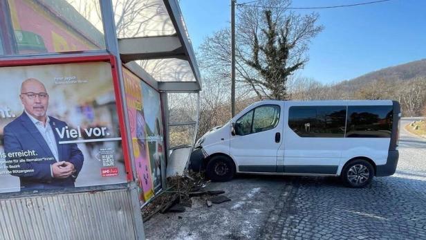 Weißer Lieferwagen prallt gegen eine Bushaltestelle, eine Werbetafel ist beschädigt.