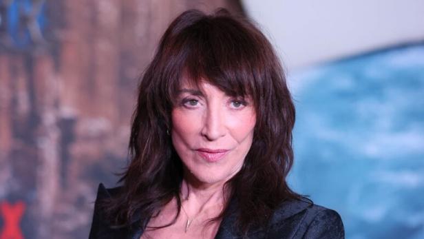 Katey Sagal mit braunem Haar trägt einen schwarzen Blazer vor einem unscharfen Hintergrund.