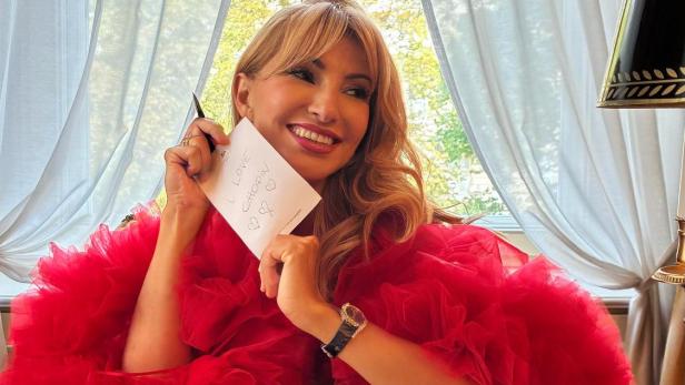 Donka Angatscheva sitzt im Hotel Imperial in einer roten Couture-Robe und hält eine Karte mit der Aufschrift „I love Chopin“.