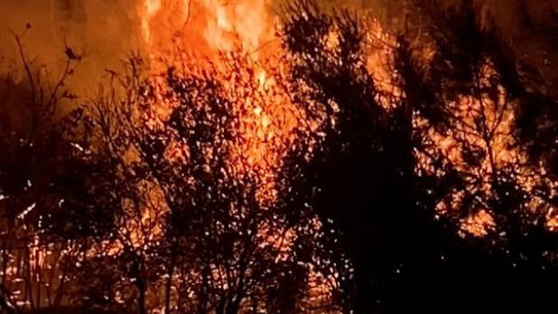 Fire and smoke rise following a wildfire in Aksu