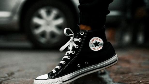 Converse-Schuh vor einer Lacke