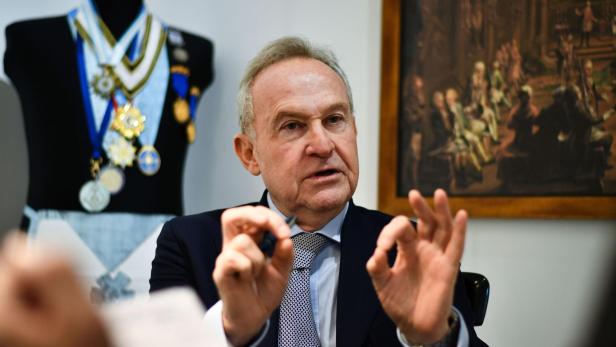 Georg Semler spricht im Freimaurer-Haus in Wien vor einem mit Orden behängten Schaufensterpuppe und einem Ritualbild.