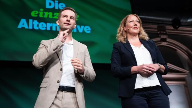 Eine Frau und ein Mann stehen vor einem Plakat mit der Aufschrift "Die einzige Alternative"