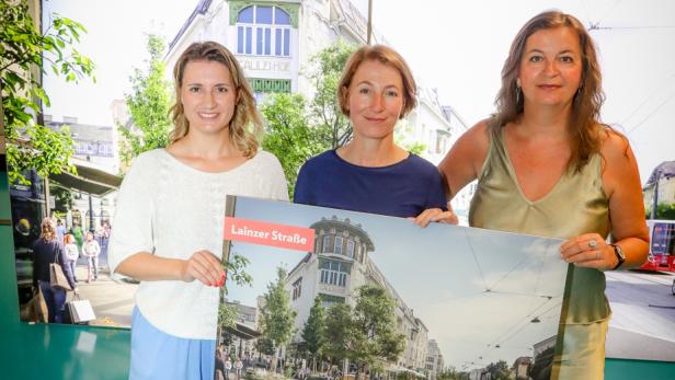 Drei Frauen präsentieren ein Plakat zur umgestalteten Lainzer Straße mit Radweg.