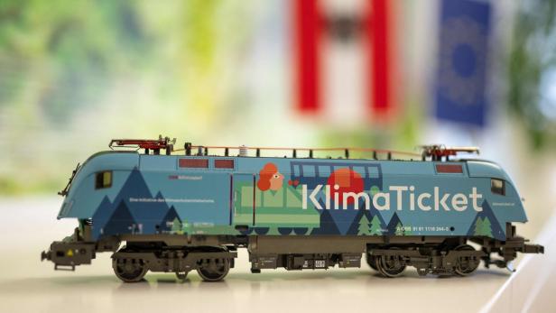 Modell-Lok in Blau mit der Aufschrift „KlimaTicket“ auf hellem Untergrund, unscharfer Hintergrund.
