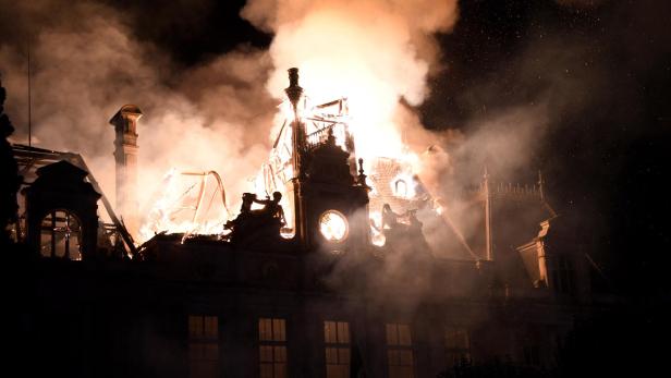 Das Rathaus von Limoges steht nachts in Flammen, während dichter Rauch und Funken aus dem stark beschädigten Dach aufsteigen.