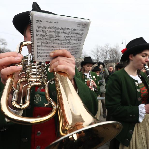 Eine Tiroler Blaskapelle spielt in Tracht auf der Straße.