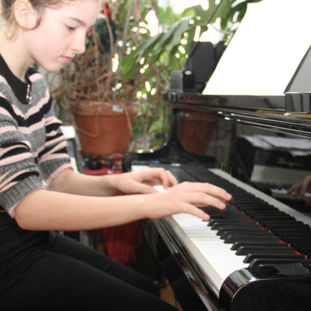 Eine 12-Jährige spielt Klavier.