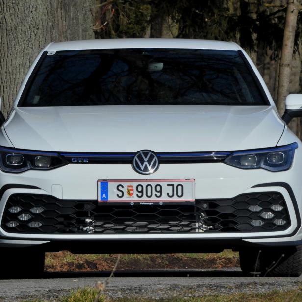 Ein weißer VW Golf GTE steht auf einer Straße.