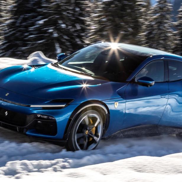 Ein blauer Ferrari Purosangue fährt durch den Schnee.